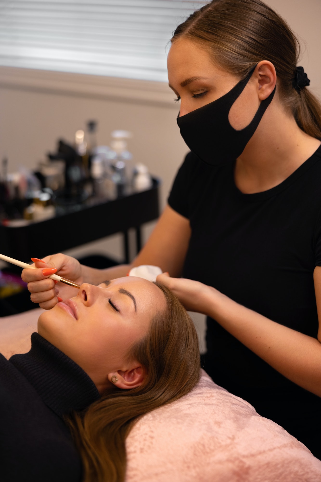 Eyelash extension procedure with master and a client in a beauty salon